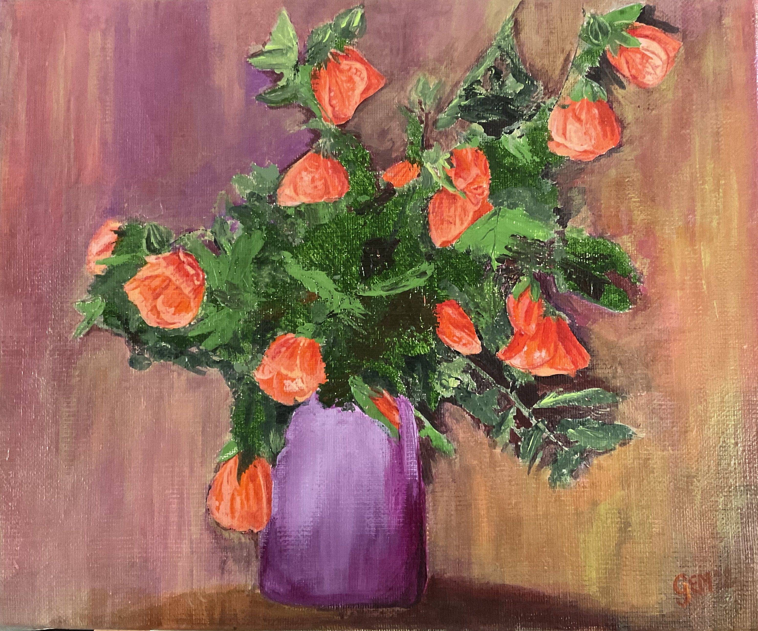 un vase bleu sur la table avec un bouquet d'abutilons